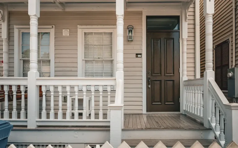 Porch and dark front door of a white house, locksmith in Belton, SC